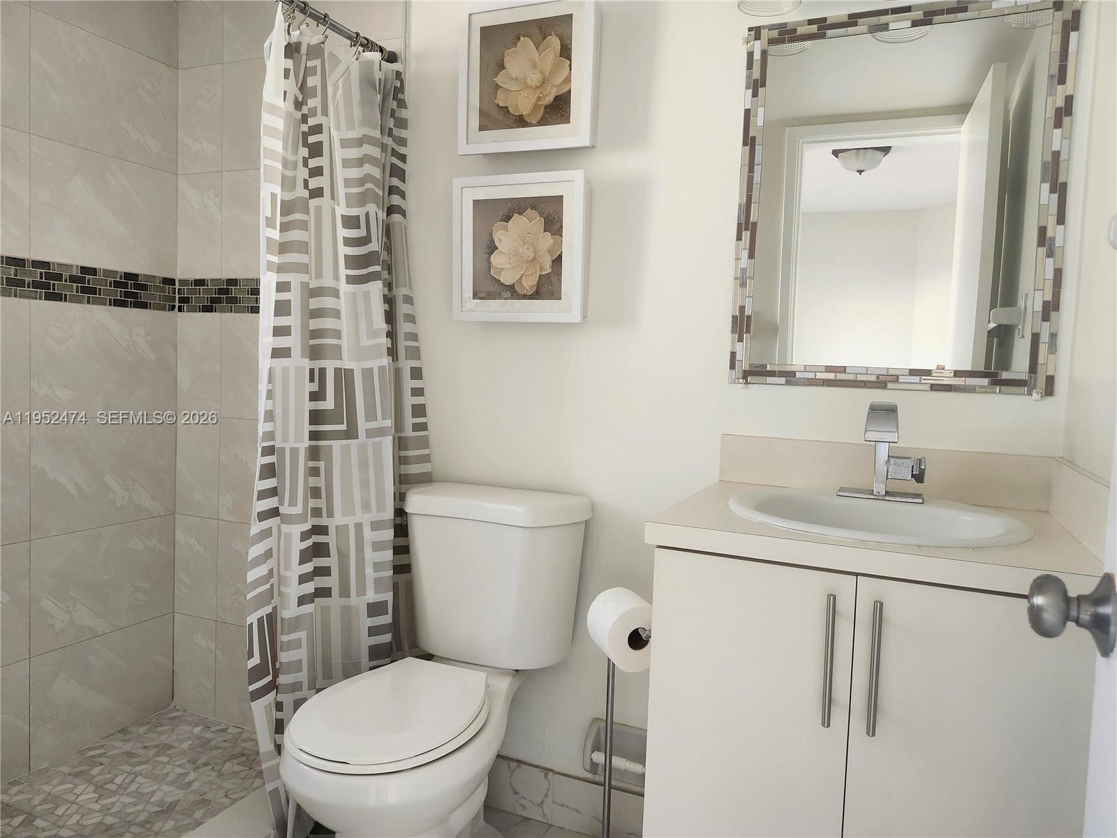 12396 Southwest 94th Lane, Unit 12396 Miami, FL 33186 - Photo 18 of 32 a bathroom with a granite countertop toilet sink and a mirror