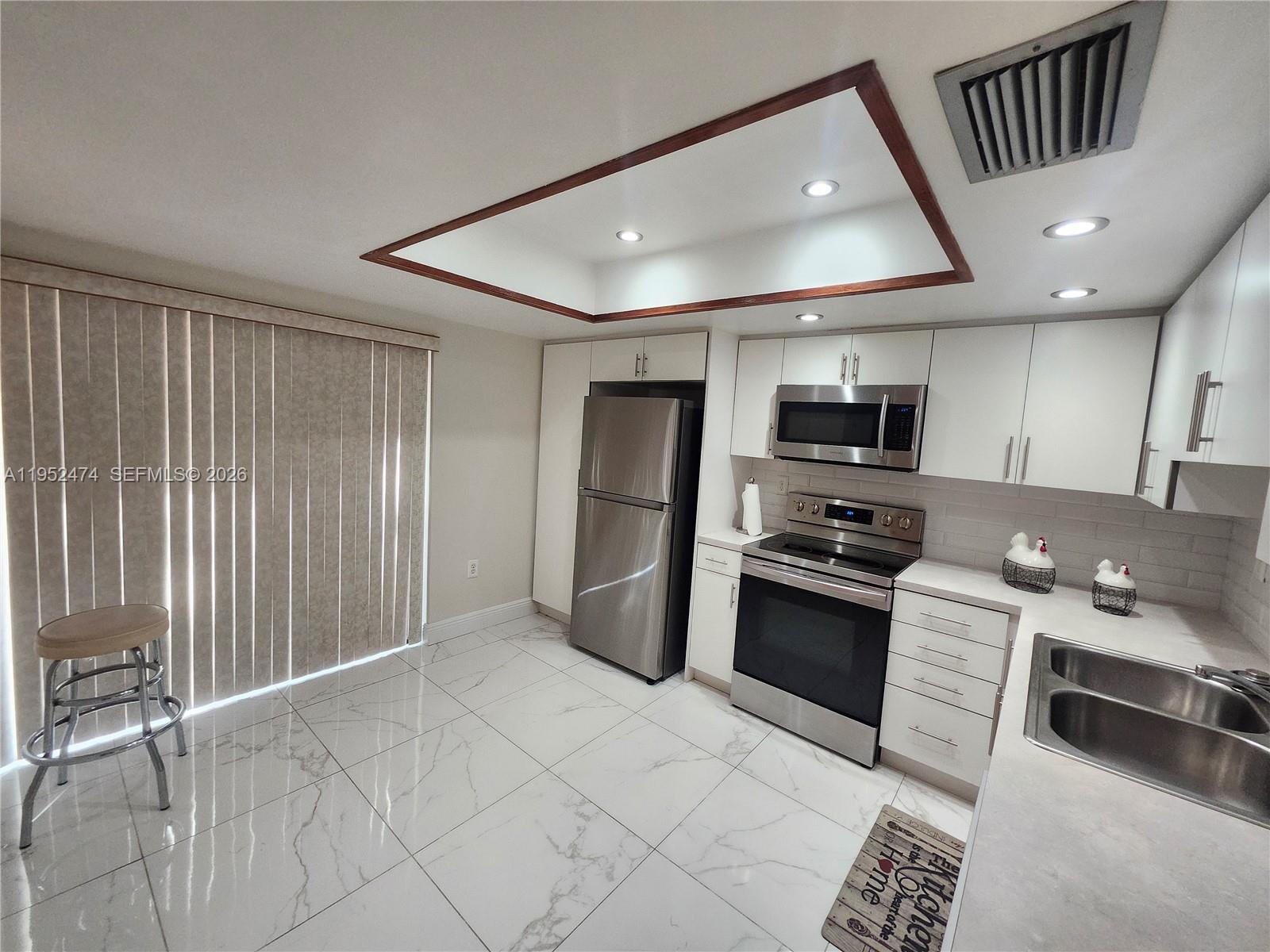 12396 Southwest 94th Lane, Unit 12396 Miami, FL 33186 - Photo 20 of 32 a kitchen with stainless steel appliances granite countertop a refrigerator and a stove top oven