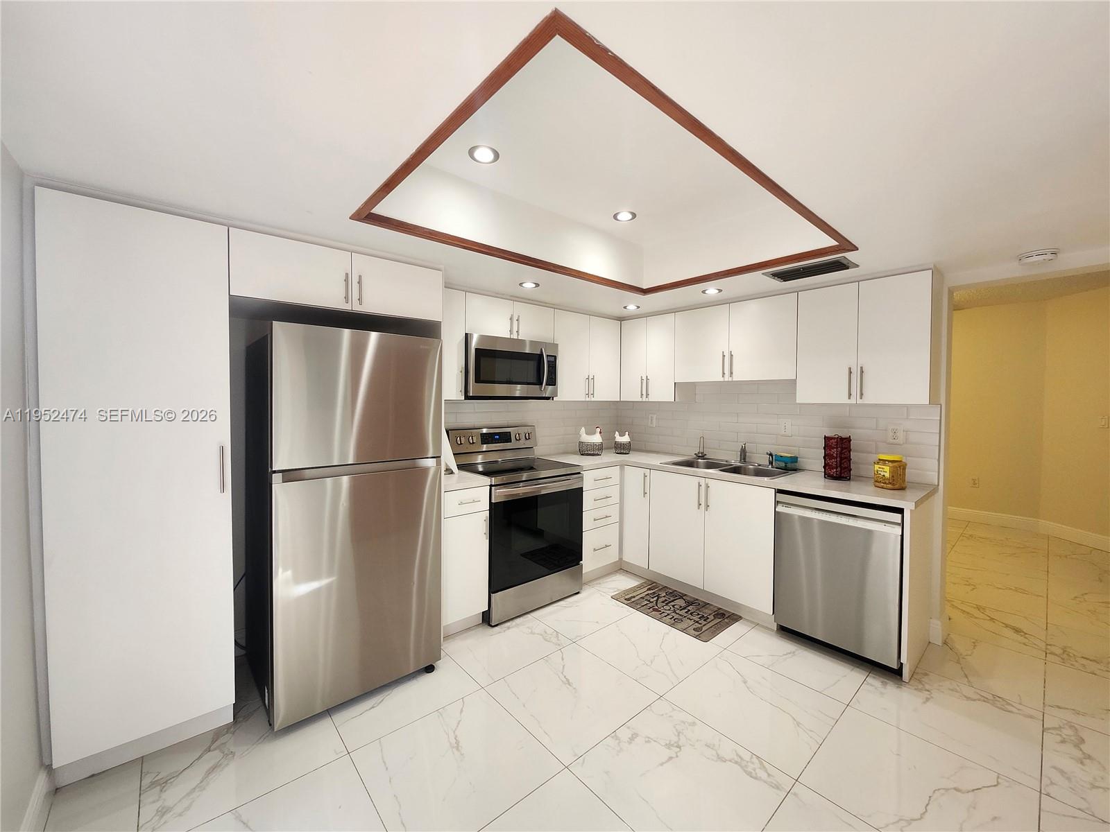 12396 Southwest 94th Lane, Unit 12396 Miami, FL 33186 - Photo 21 of 32 a kitchen with stainless steel appliances granite countertop a refrigerator and a stove top oven