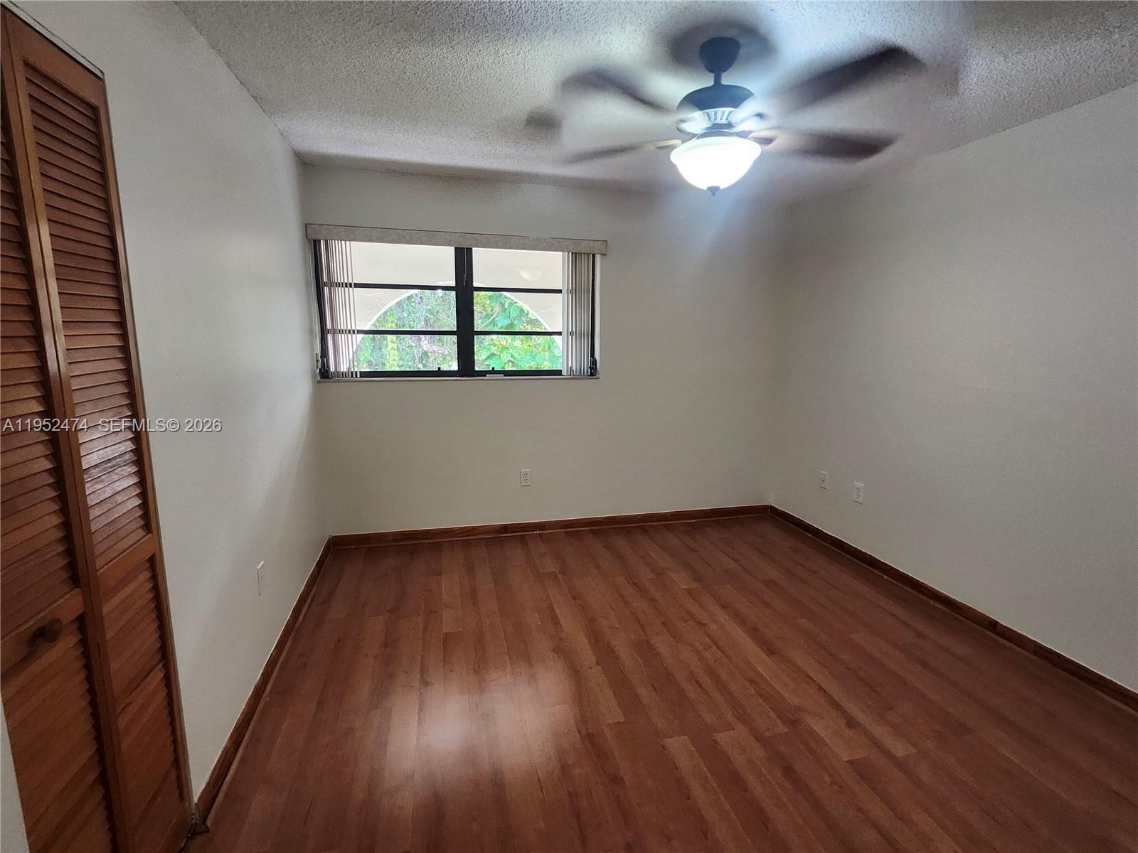 12396 Southwest 94th Lane, Unit 12396 Miami, FL 33186 - Photo 26 of 32 wooden floor in an empty room with a window