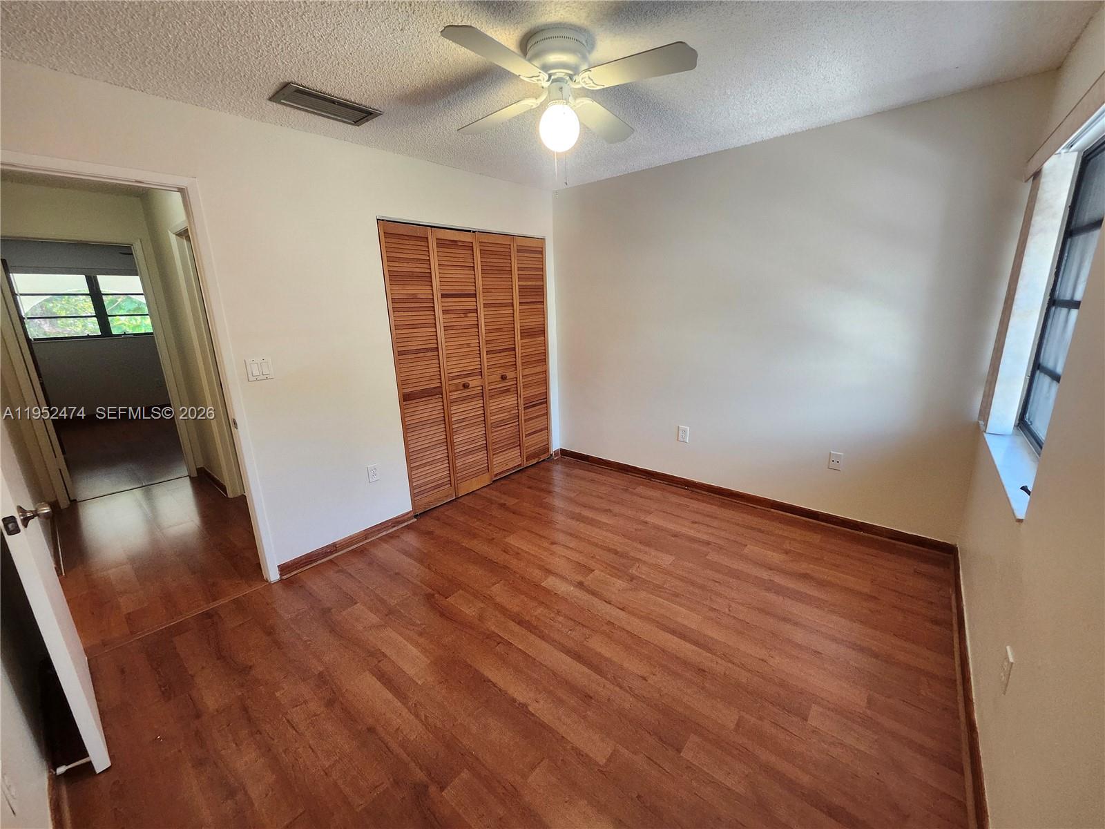 12396 Southwest 94th Lane, Unit 12396 Miami, FL 33186 - Photo 27 of 32 wooden floor in an empty room with a window