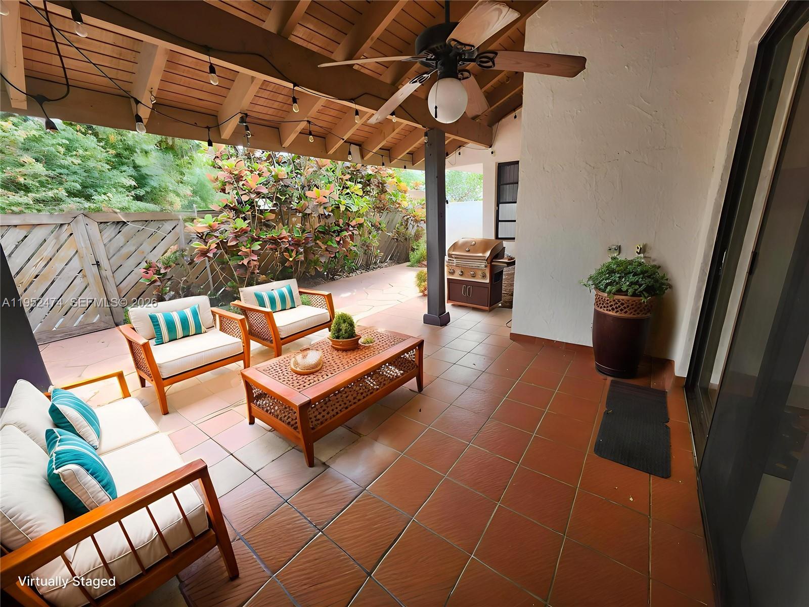 12396 Southwest 94th Lane, Unit 12396 Miami, FL 33186 - Photo 3 of 32 a living room with patio furniture and a potted plants