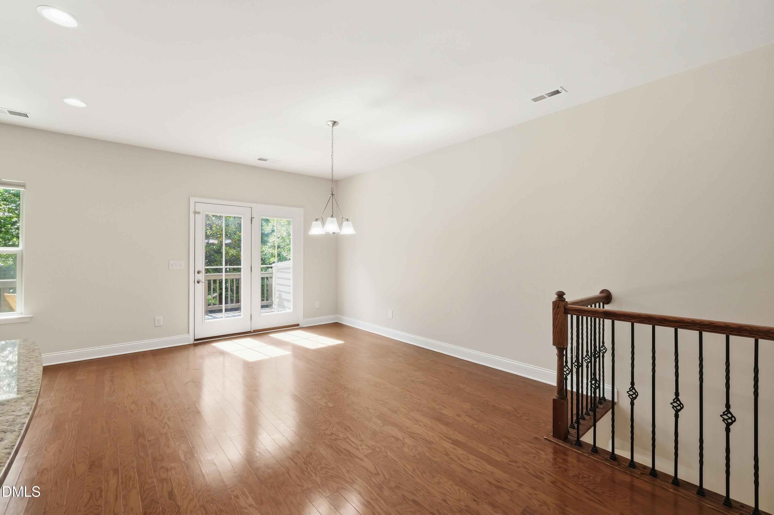 1004 Waymaker Court Apex, NC 27502 - Photo 10 of 30 an empty room with wooden floor and windows