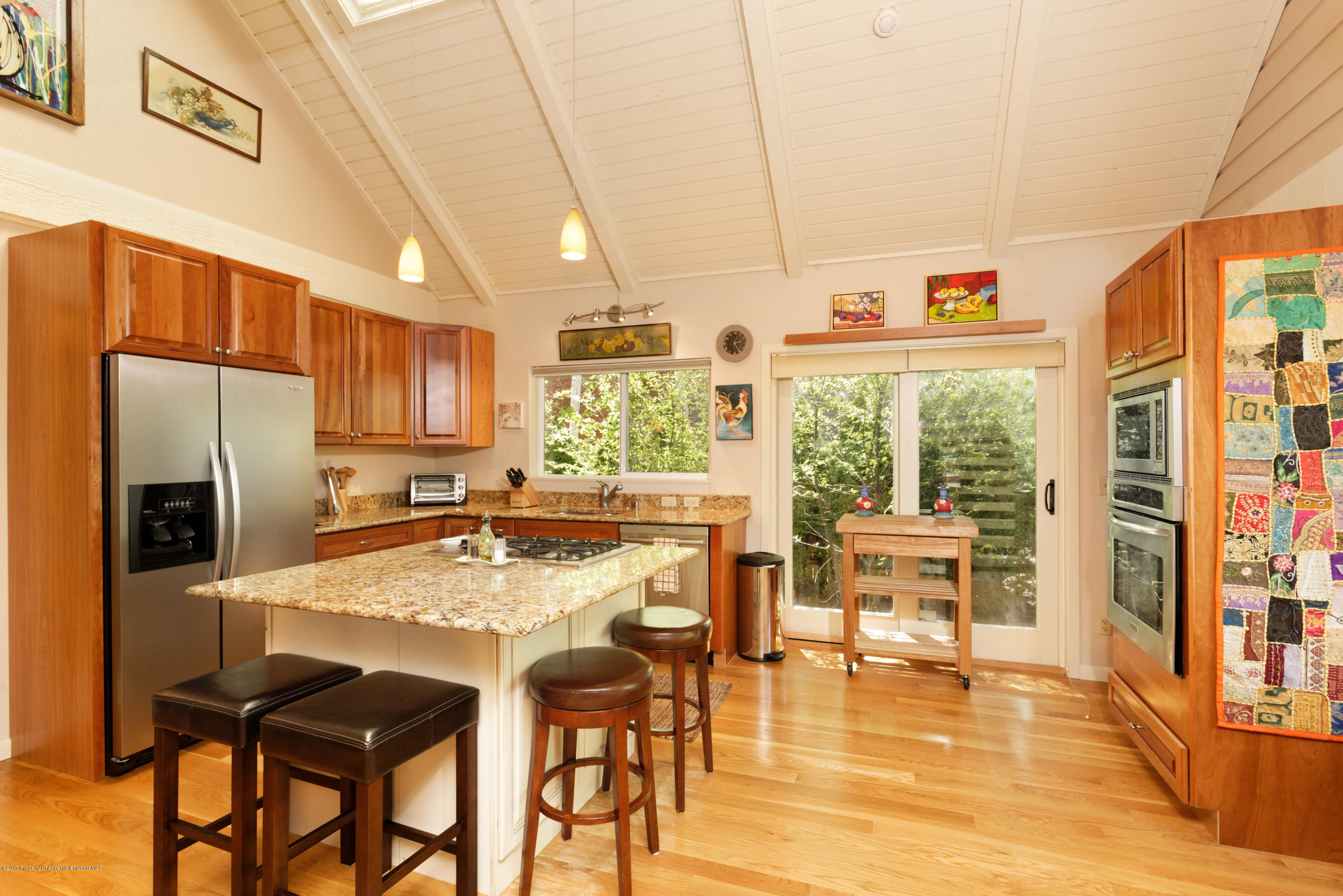 295 Riverside Drive Basalt, CO 81621 - Photo 3 of 27 a kitchen with stainless steel appliances granite countertop a stove top oven a refrigerator a dining table and chairs with the view of living room