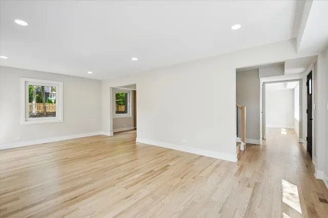 an empty room with wooden floor and a window