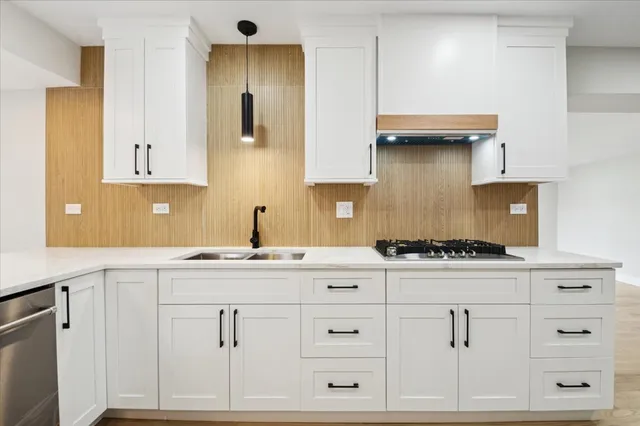 a kitchen with white cabinets and sink