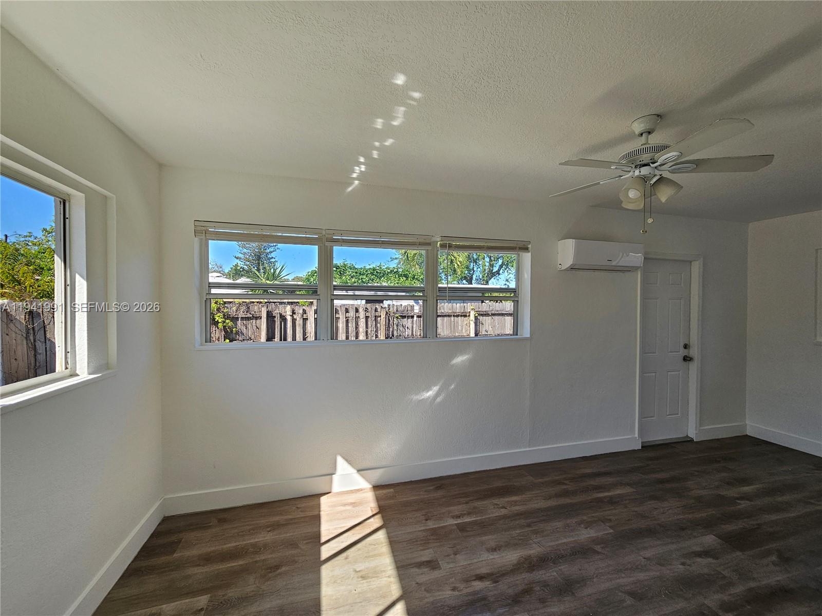 5621 Cleveland Street Hollywood, FL 33021 - Photo 14 of 19 a view of an empty room with wooden floor and a window