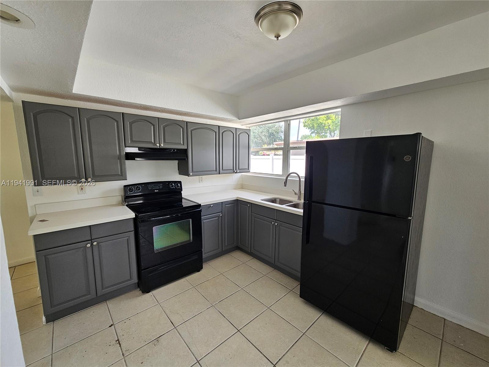 5621 Cleveland Street Hollywood, FL 33021 - Photo 4 of 19 a kitchen with a refrigerator and a sink