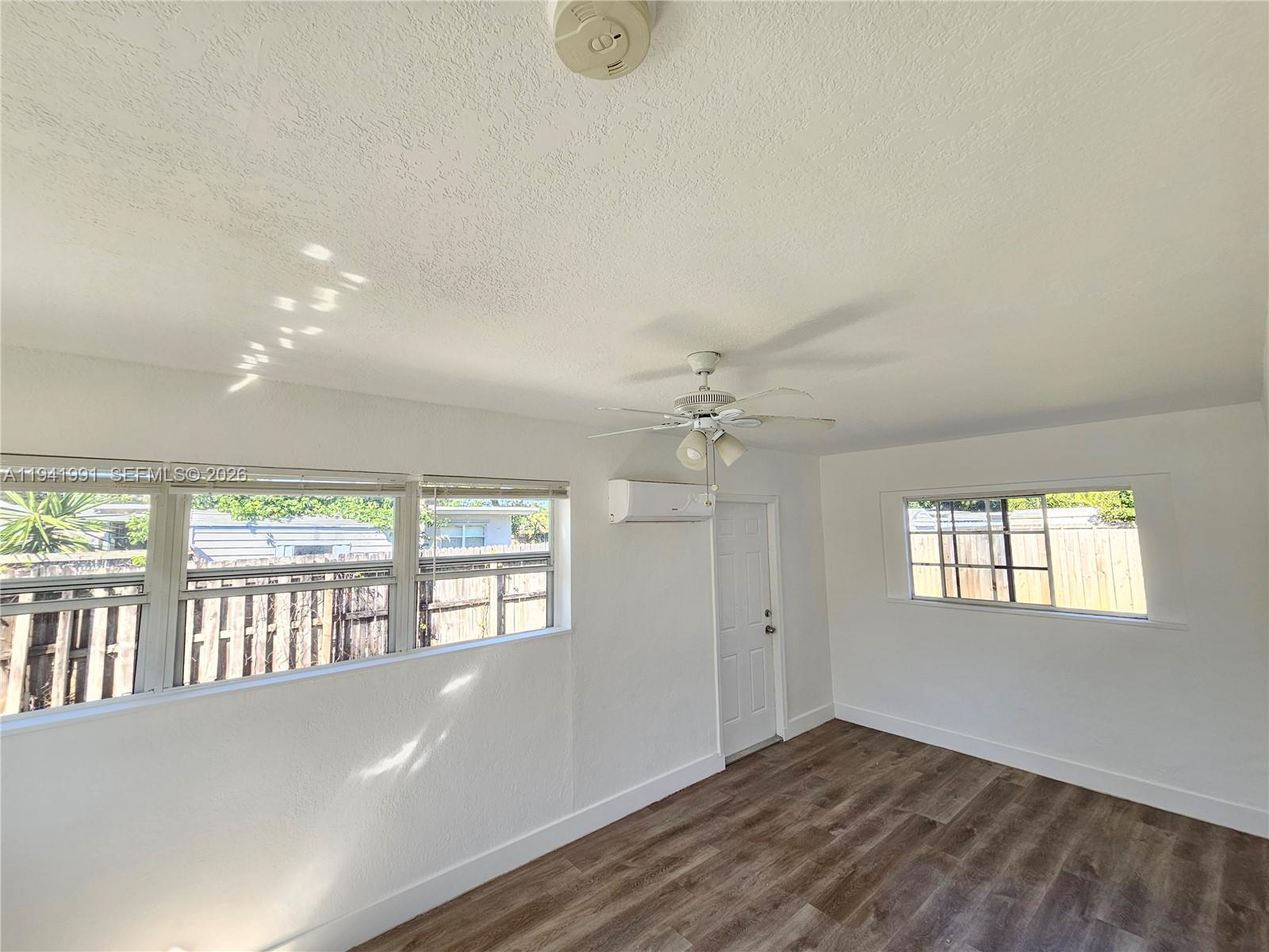 5621 Cleveland Street Hollywood, FL 33021 - Photo 5 of 19 an empty room with wooden floor and windows