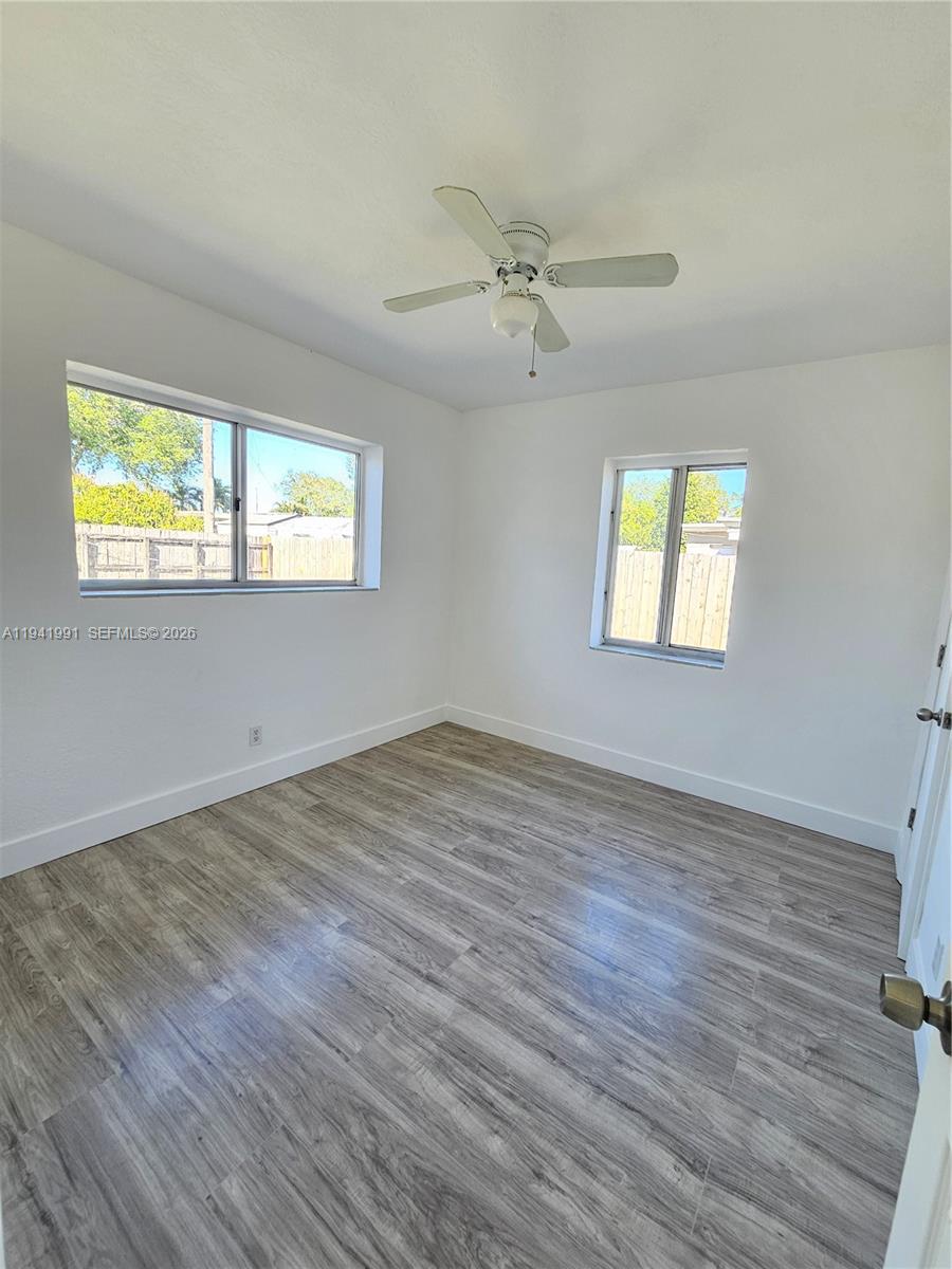 5621 Cleveland Street Hollywood, FL 33021 - Photo 7 of 19 a view of empty room with wooden floor and fan