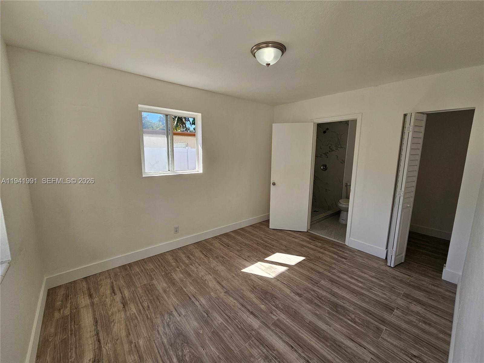 5621 Cleveland Street Hollywood, FL 33021 - Photo 8 of 19 an empty room with wooden floor and windows