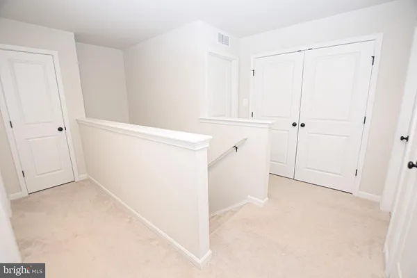 a bedroom with a bed and a flat tv screen on the dresser