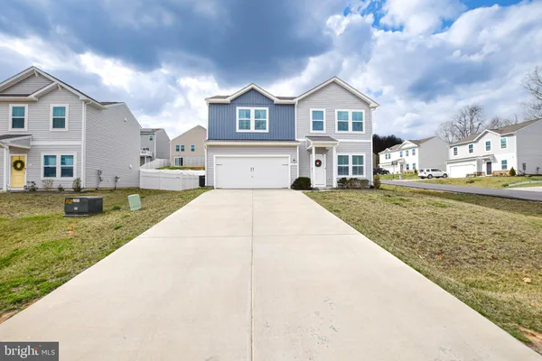 a front view of a house with a garden and trees
