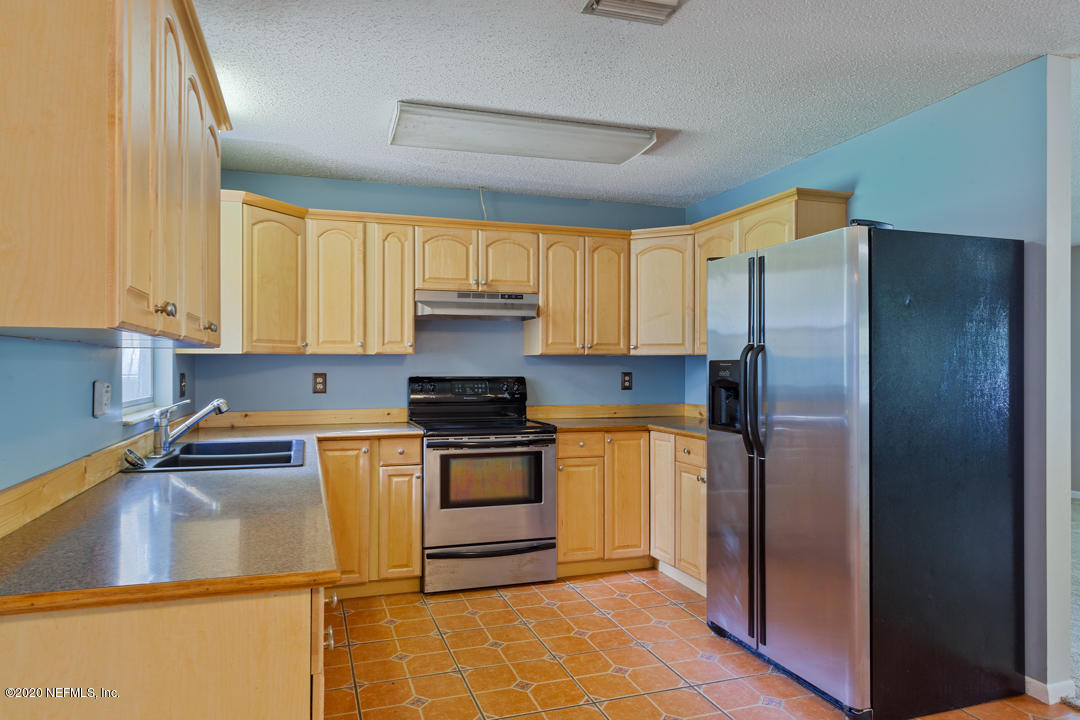 6576 Immokalee Road Keystone Heights, FL 32656 - Photo 22 of 31 a kitchen with stainless steel appliances granite countertop a refrigerator sink and stove