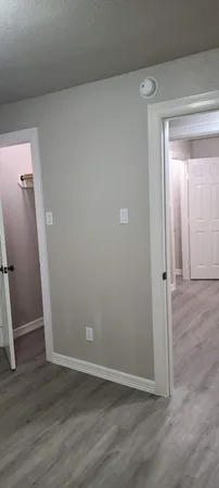 an empty room with wooden floor and entrance