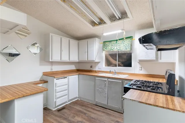 a kitchen with granite countertop a sink stove and cabinets