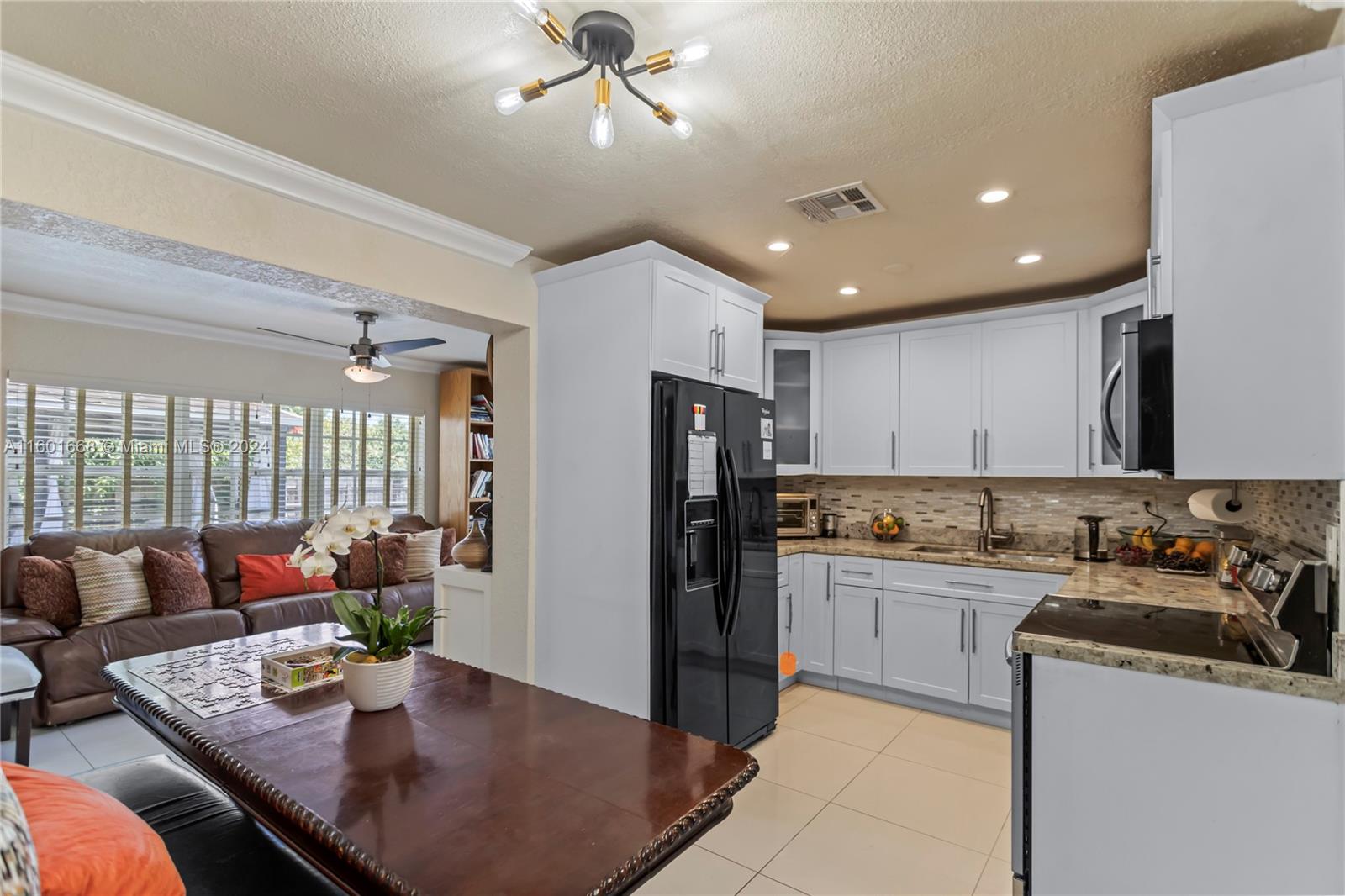 2919 Southwest 68th Avenue Miramar, FL 33023 - Photo 13 of 46 a kitchen with sink refrigerator dining table and chairs