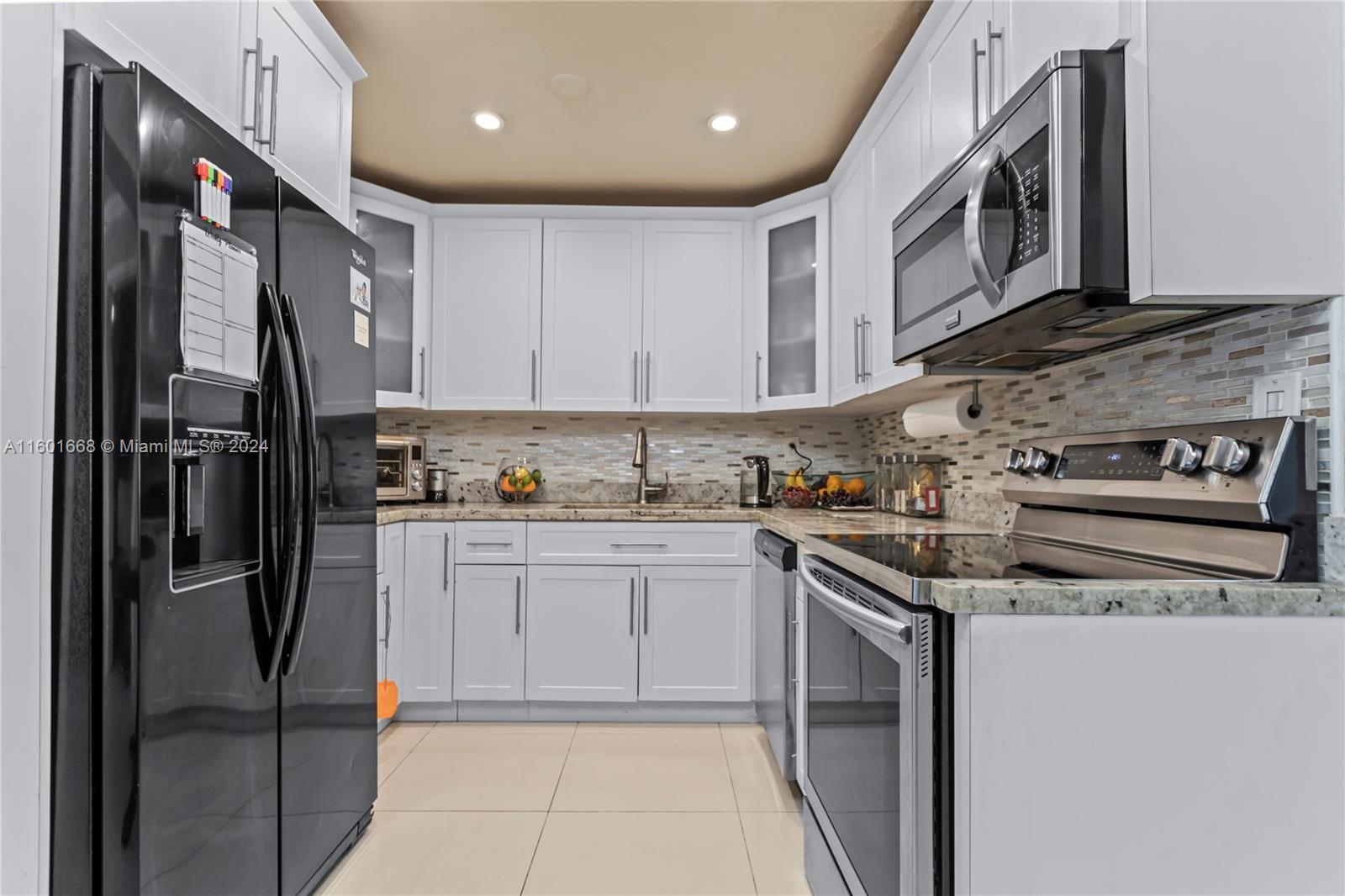 2919 Southwest 68th Avenue Miramar, FL 33023 - Photo 14 of 46 a kitchen with stainless steel appliances granite countertop a refrigerator and a stove top oven