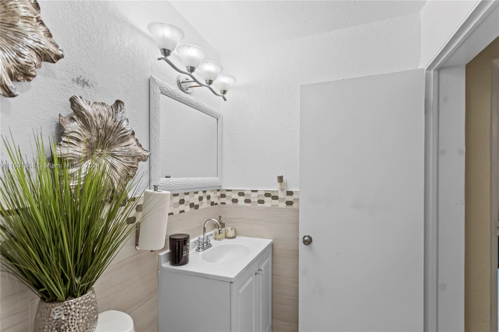 2919 Southwest 68th Avenue Miramar, FL 33023 - Photo 23 of 46 a bathroom with a sink a mirror and a potted plant