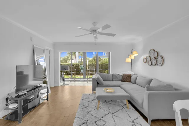 a living room with furniture a flat screen tv and a large window