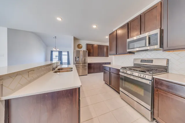 a kitchen with stainless steel appliances wooden floor and large kitchen view