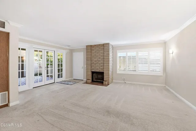 a view of an empty room with a fireplace and a window