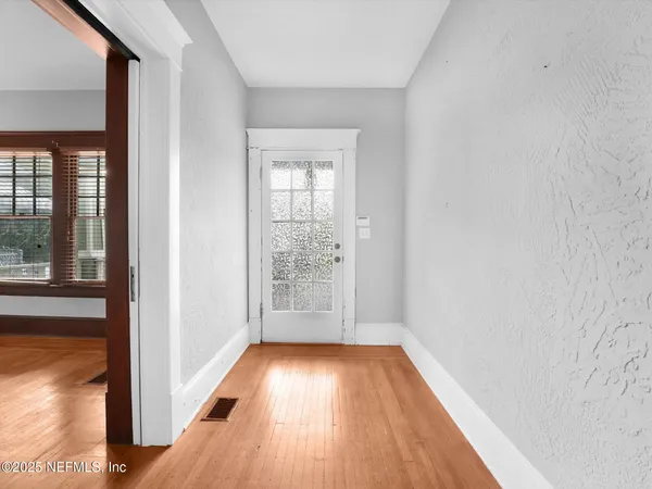 a view of a livingroom with a fireplace wooden floor and windows