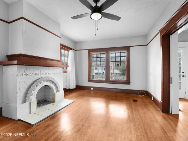 a view of empty room with a fireplace and wooden floor