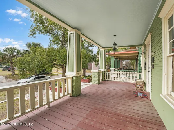 a view of a porch with wooden floor and floor to ceiling window