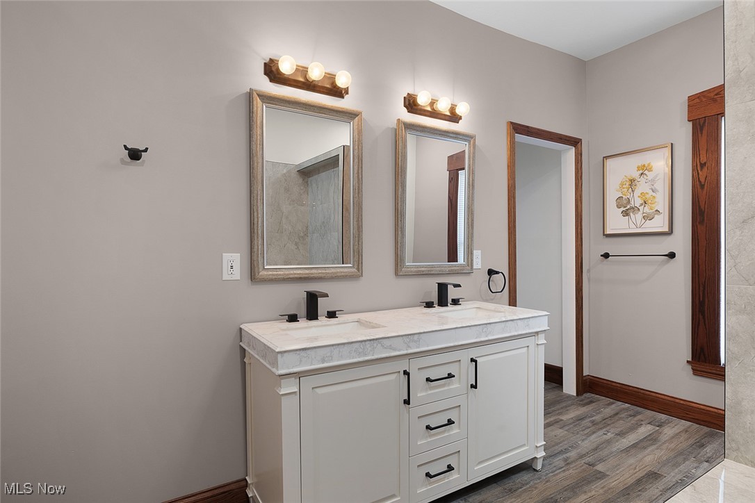 11794 Vermilion Road Oberlin, OH 44074 - Photo 12 of 34 Bathroom featuring double vanity, a sink, baseboards, and wood finished floors
