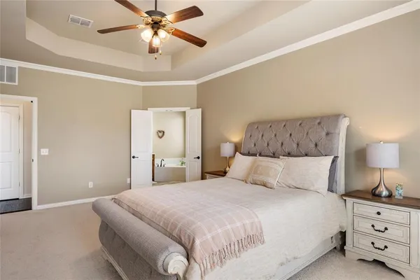 a bedroom with a large bed and a chandelier