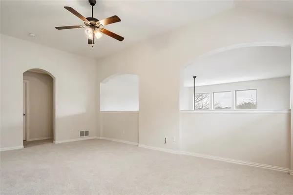 an empty room with windows and fan view