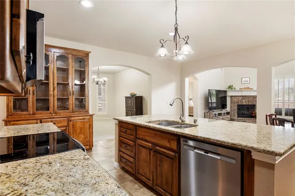 a kitchen with kitchen island granite countertop a sink stove and refrigerator