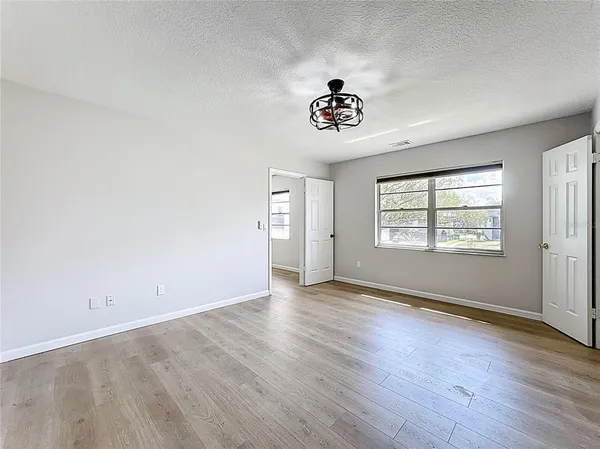 an empty room with a window and a ceiling fan
