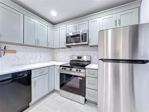 a kitchen with a refrigerator sink and cabinets
