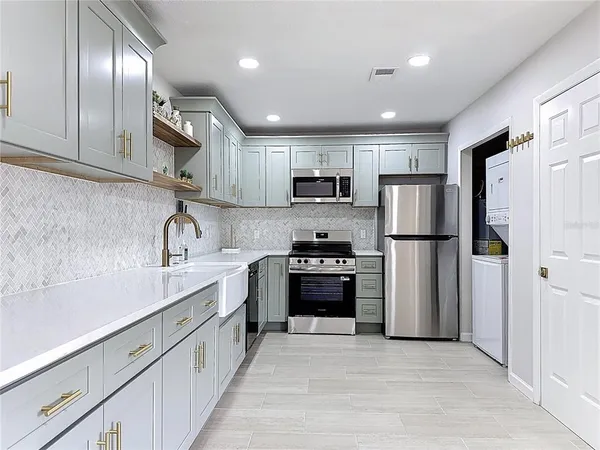 a kitchen with stainless steel appliances granite countertop a refrigerator sink and stove