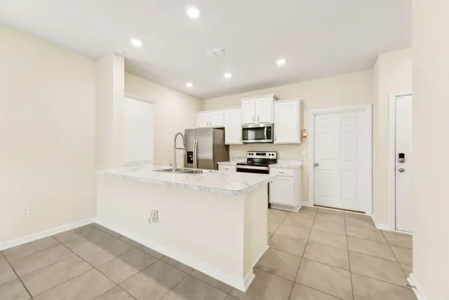 a kitchen with stainless steel appliances a refrigerator sink and microwave
