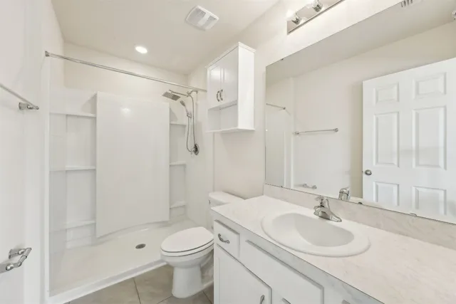 a bathroom with a sink toilet mirror and shower