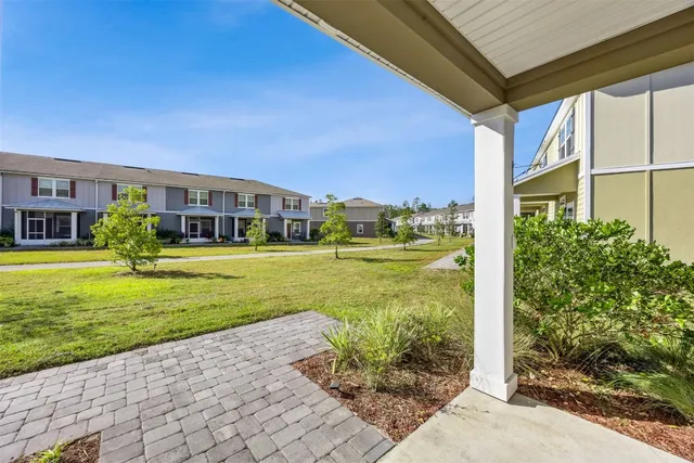 a view of a house with a big yard and potted plants