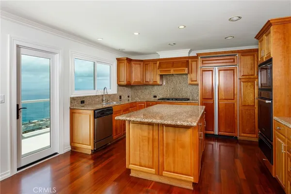 a kitchen with granite countertop wooden floors and stainless steel appliances