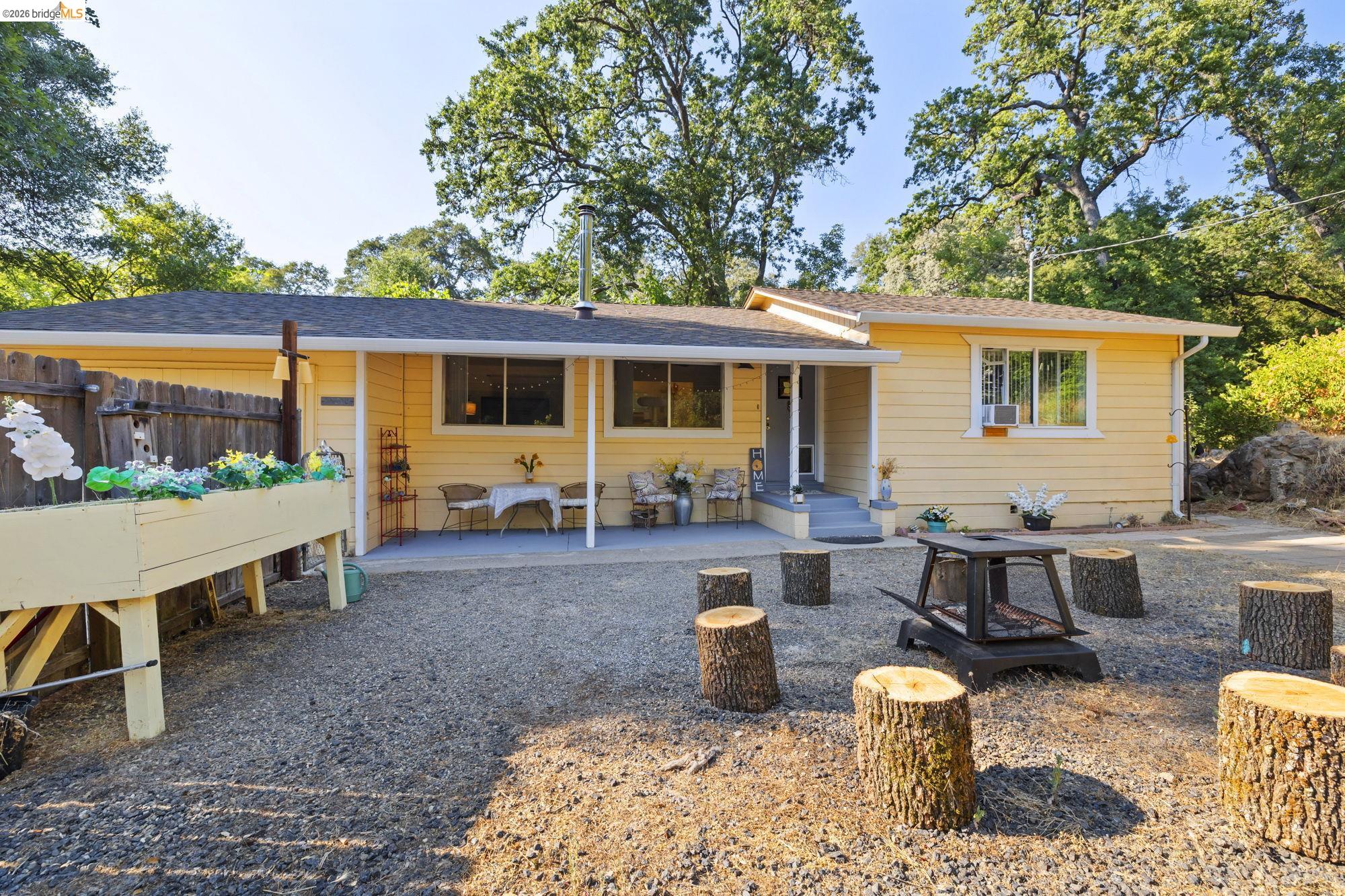 15518 Jenness Road Sonora, CA 95370 - Photo 1 of 1 a view of a house with backyard sitting area and garden