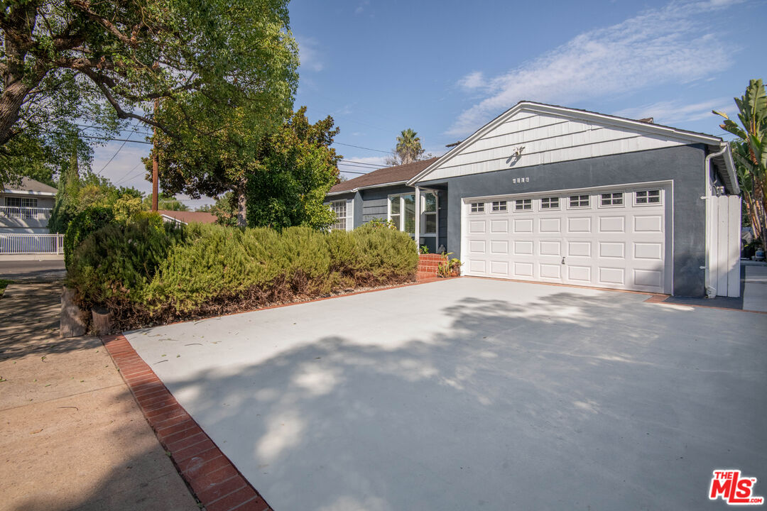 6218 Balcom Avenue Encino, CA 91316 - Photo 2 of 22 a front view of a house with a yard and garage