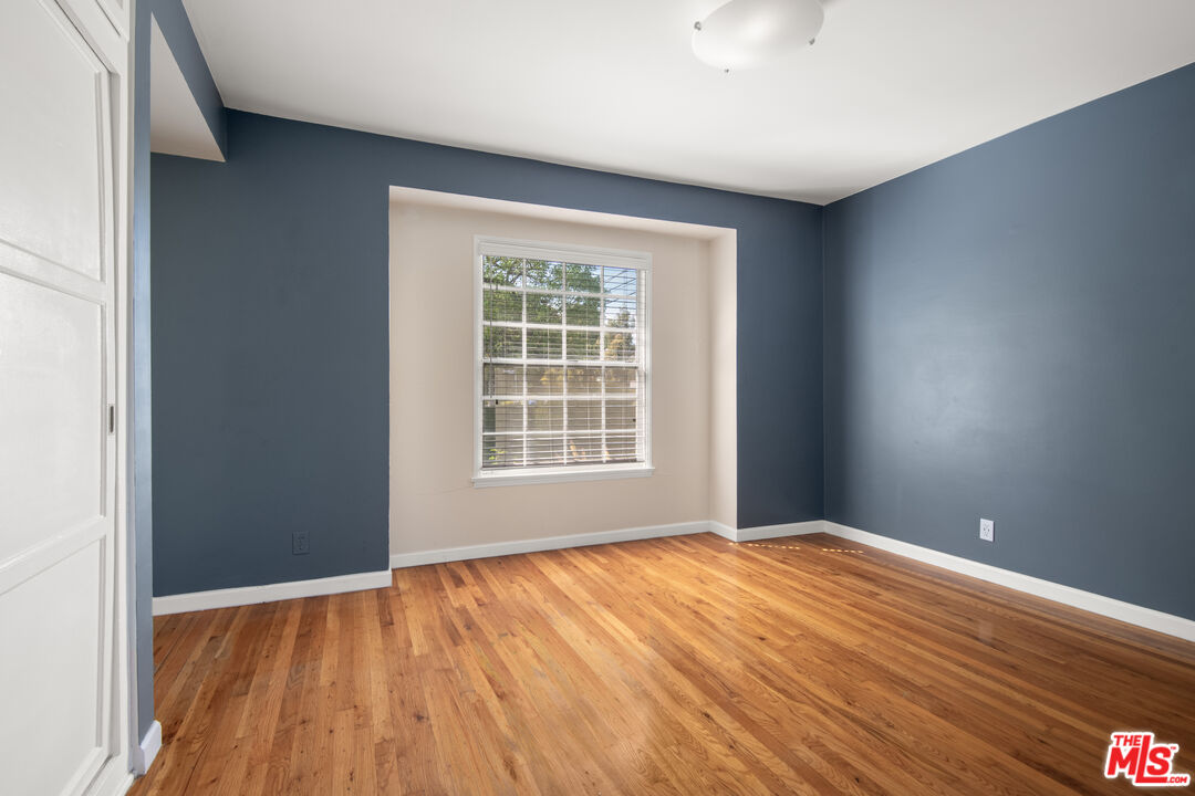 6218 Balcom Avenue Encino, CA 91316 - Photo 8 of 22 an empty room with wooden floor and windows