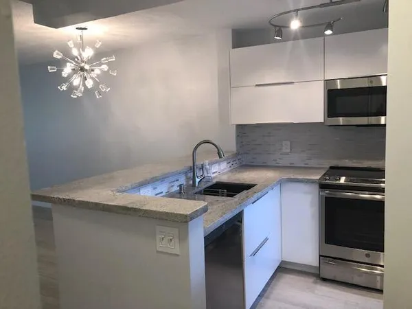 a kitchen with stainless steel appliances granite countertop a stove a sink and a microwave