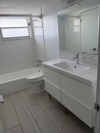 a bathroom with a bathtub sink vanity and toilet