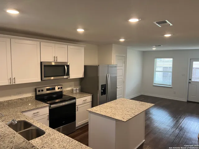 a kitchen with a refrigerator and a stove top oven
