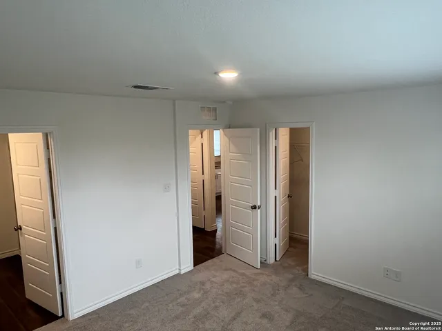 an empty room with closet and mirror