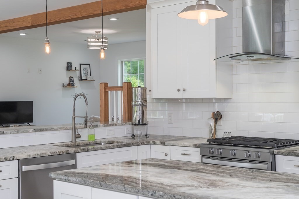 77 Jourdan Road Montgomery, MA 01085 - Photo 22 of 42 a kitchen with kitchen island granite countertop a sink a stove and cabinets
