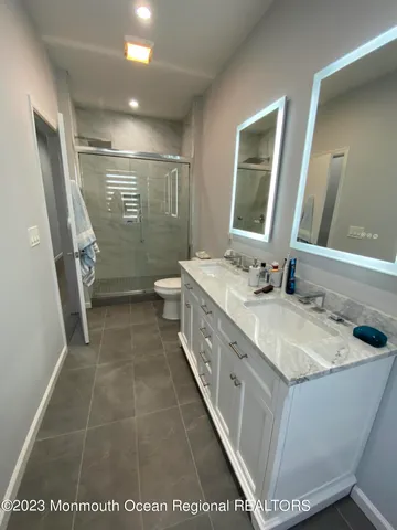 a bathroom with a sink a toilet and a mirror