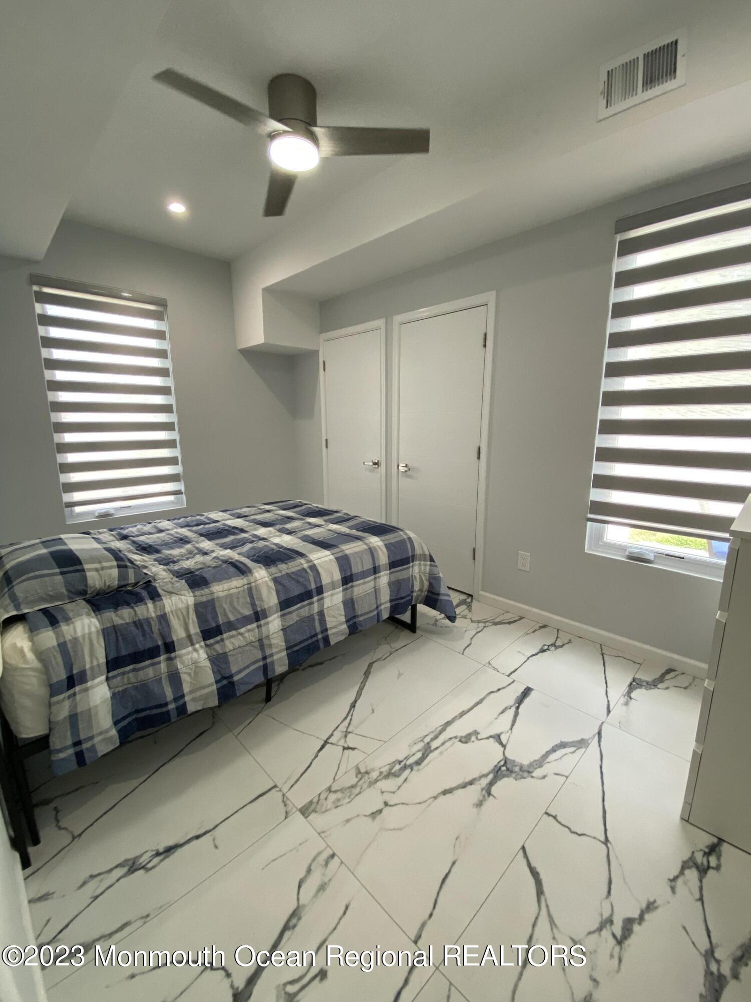 975 Van Ct Avenue Long Branch, NJ 07740 - Photo 15 of 16 a bedroom with a bed and a chandelier